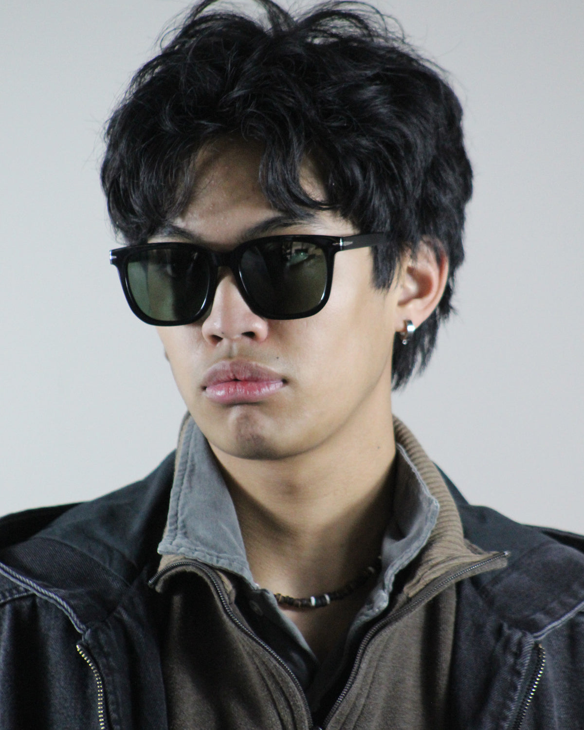 The Corsair Black/Green sunglasses worn on model